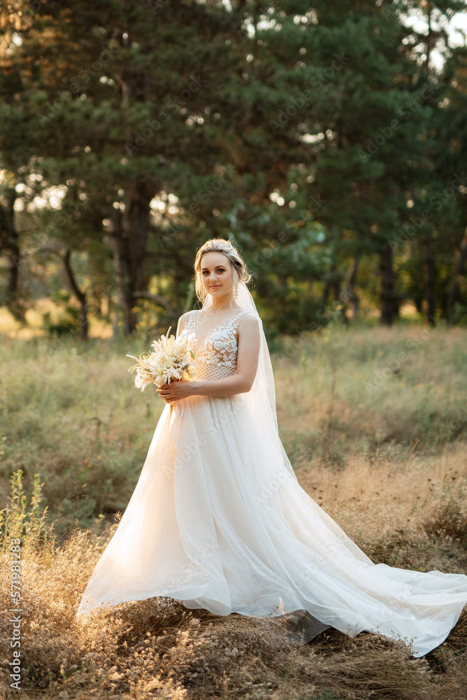 bride blonde girl with a bouquet in the forest