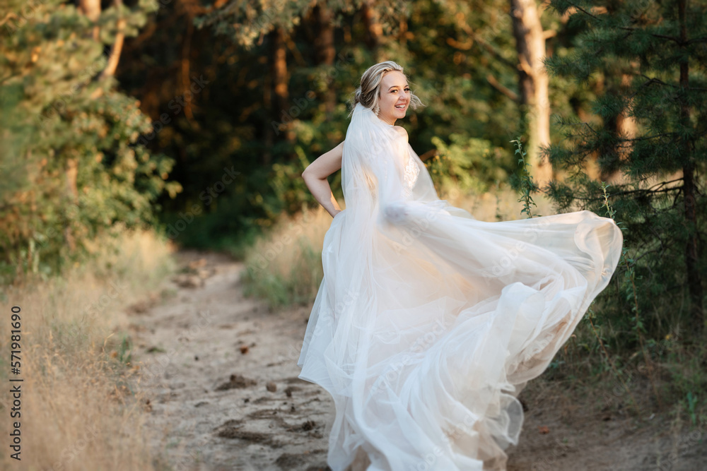 bride blonde girl with a bouquet in the forest