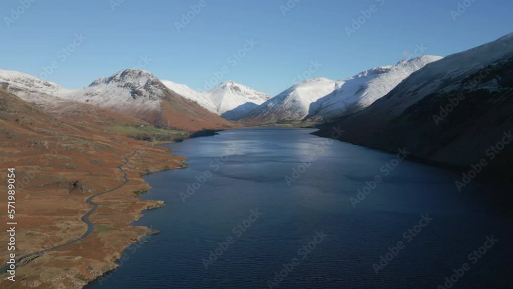 Flying high over dark lake surrounded by snow capped mountains at Wasdale Lake District UK Flying high over dark lake surrounded by snow capped mountains at Wasdale Lake District UK