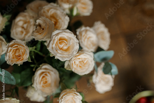 A beautiful bouquet of cream roses on a wooden background. Soft focus.