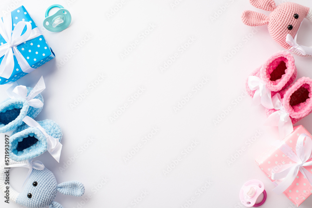 Gender reveal party concept. Top view photo of pink and blue knitted booties gift boxes bunny rattle toys and soothers on isolated white background with copyspace - obrazy, fototapety, plakaty 