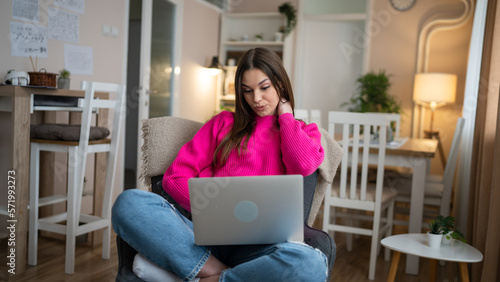 One young woman use laptop computer at home while sit comfortable