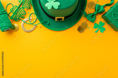 Top view photo of leprechaun headwear giftbox clover shaped party glasses spool of twine bow-tie gold coins shamrocks horseshoe and sprinkles on isolated yellow background with blank space