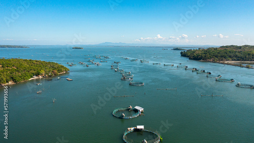 Fish farm with cages for fish and shrimp. Fish ponds for bangus, milkfish. Farming aquaculture or pisciculture practices. Philippines, Luzon.
