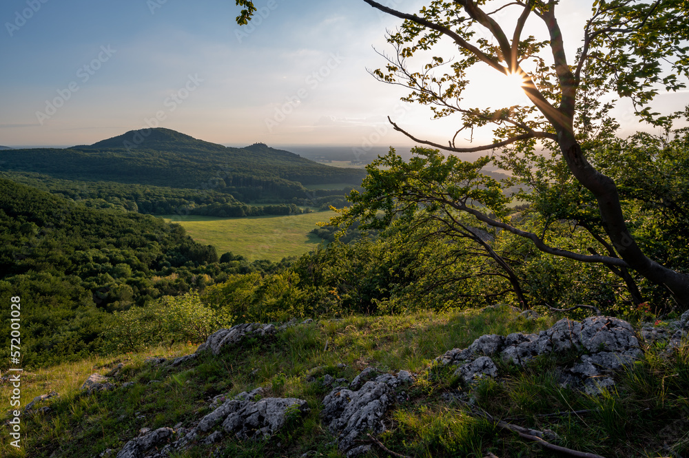 view of hill meadows and Spiš Castle in the Slovak Little Carpathian Mountains with the setting sun in the background view of hill meadows and Spiš Castle in the Slovak Little Carpathian Mountains with the setting sun in the background