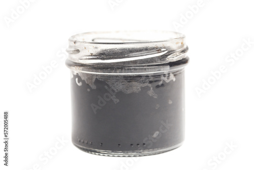 Black caviar in a glass jar isolated on white background.