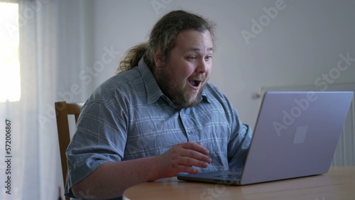 One excited chubby guy celebrating success in front of laptop computer. male person dancing in happiness. WOW emotion © Marco
