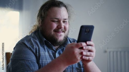 Joyful guy holding phone liking content online. Happy emotion of male casual person feeling excitement