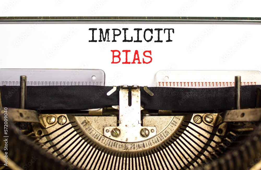 Implicit bias symbol. Concept words Implicit bias typed on white paper on old retro typewriter. Beautiful white background. Business psychology implicit bias concept. Copy space.