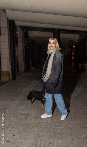 Photography Young beautiful hipster girl is walking her pet small dog at night that she adop