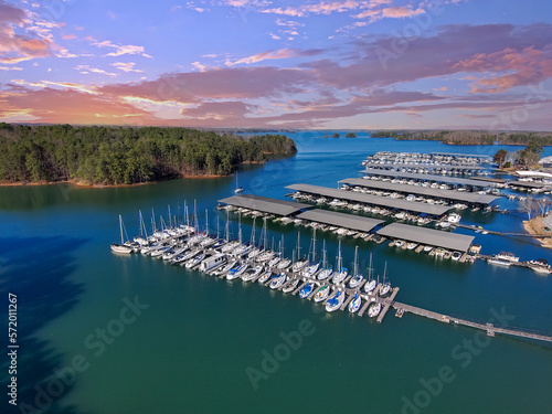 aerial shot of the boats and yachts docked in the marina on the waters of Lake Lanier surrounded by lush green trees with powerful clouds at sunset in Buford Georgia USA photo