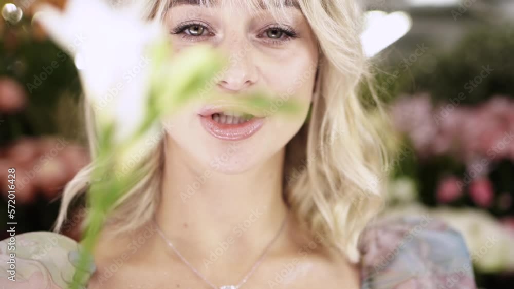 beautiful girl playing with the flower. pretty girl with the flower in flower shop beautiful girl playing with the flower. pretty girl with the flower in flower shop