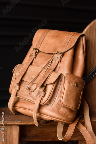 photo of a light brown leather backpack with antique and retro look. indoors photo