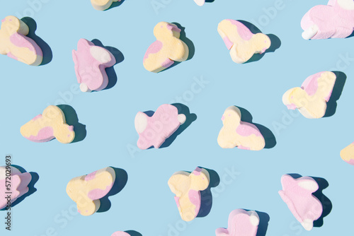 Marshmallows, chickens and rabbits, creative Easter pattern, pastel blue background. 
