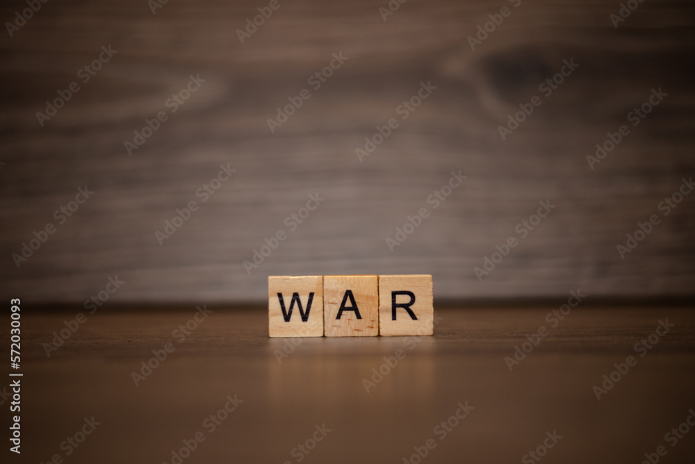 The word war is made up of wooden cubes tablets on a dark wooden background The word war is made up of wooden cubes tablets on a dark wooden background