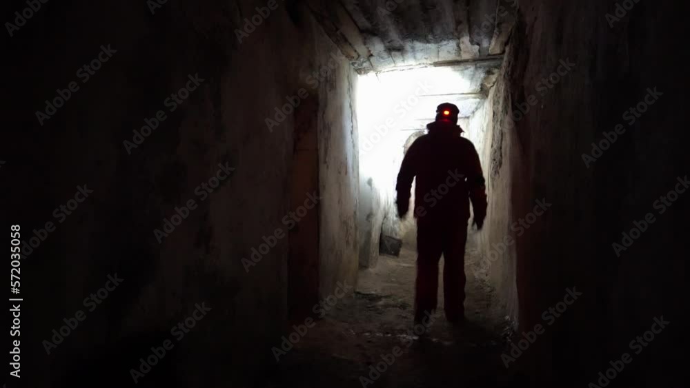 The guy went into the corridor of the old prison. Looking for something and considering everything. Entrances to small cells are visible. A metal door from the oven in the wall. Old walls. Night The guy went into the corridor of the old prison. Looking for something and considering everything. Entrances to small cells are visible. A metal door from the oven in the wall. Old walls. Night
