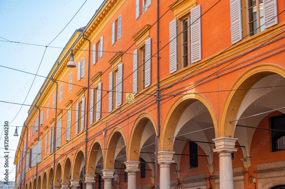 Low Angle wide View Of orange Historical Building in Modena with arcs, Emilia Romagna, Italy