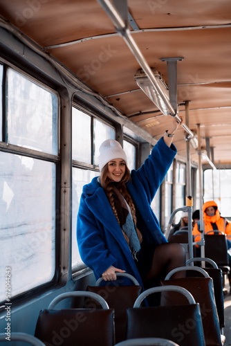 a girl with a blue coat rides a tram