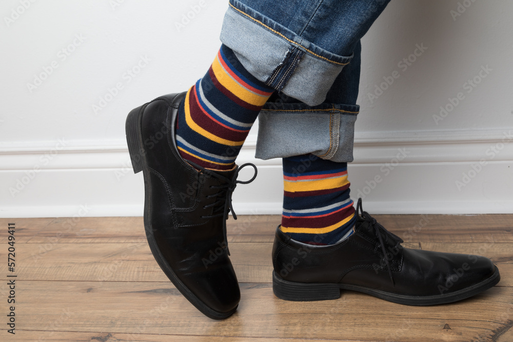 Product photo of men's colourful socks, black dress shoes, and jeans.  Stock-Foto | Adobe Stock