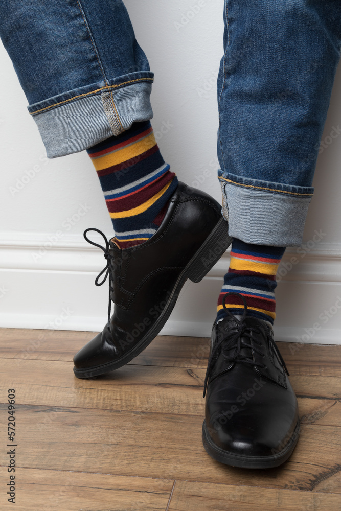 Product photo of men's colourful socks, black dress shoes, and jeans. Product photo of men's colourful socks, black dress shoes, and jeans.
