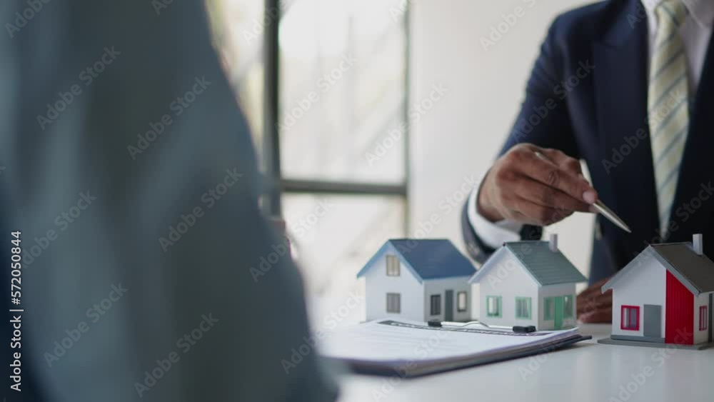 Close up of business's hands selling and signing agreement paperwork dealing for loan financial to buying the house properties. Close up of business's hands selling and signing agreement paperwork dealing for loan financial to buying the house properties.