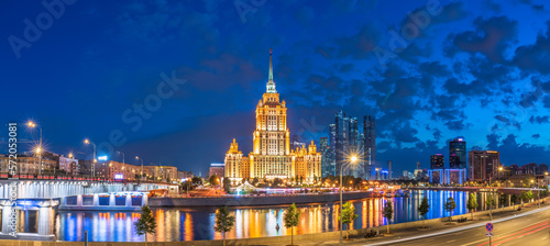 Illuminated high-rise stalinist building near river at summer night in Moscow, Russia. Historic name is Hotel Ukraina. © Dmitrii Potashkin