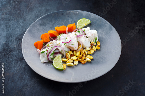 Traditionelles peruanische Ceviche Filet Stücke vom Wolfsbarsch mit Süßkartoffeln und Cancha mariniert und in Limettensauce serviert als close-up auf einem modernen Design Teller photo