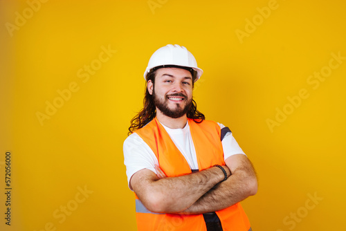 portrait of Hispanic bearded young man engineering and worker with hard helmet in Mexico Latin America on blue background 