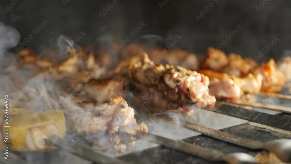 Thick white smoke comes from roasting pieces of shish kebab strung on skewers and cooked on a professional brick grill. Roasting meat from hot charcoal. Armenian khorovats Thick white smoke comes from roasting pieces of shish kebab strung on skewers and cooked on a professional brick grill. Roasting meat from hot charcoal. Armenian khorovats