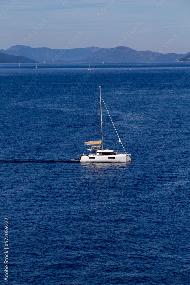 yacht cruises on the Adriatic Sea in the region of Dubrovnik, Croatia, with islands in the background, sunny day, clear weather, intense blue. yacht cruises on the Adriatic Sea in the region of Dubrovnik, Croatia, with islands in the background, sunny day, clear weather, intense blue.
