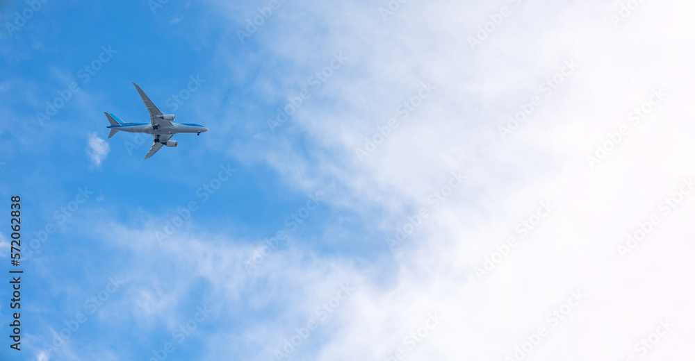 View of airplane flying in blue sky among white clouds. Banner, copy space. High quality photo View of airplane flying in blue sky among white clouds. Banner, copy space. High quality photo