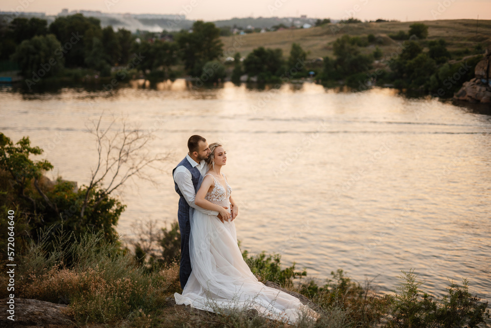 bride blonde girl and groom near the river bride blonde girl and groom near the river