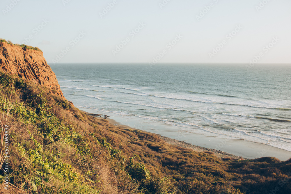cliffs bluff over the ocean sea with waves and greenery