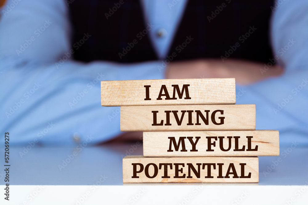 Wooden blocks with words 'I am living my full potential'. Wooden blocks with words 'I am living my full potential'.