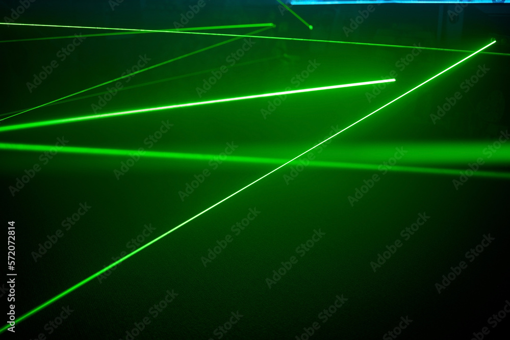 Bright green neon laser lights illuminate the darkness creating lines and triangle shapes in sci-fi effect. - obrazy, fototapety, plakaty 