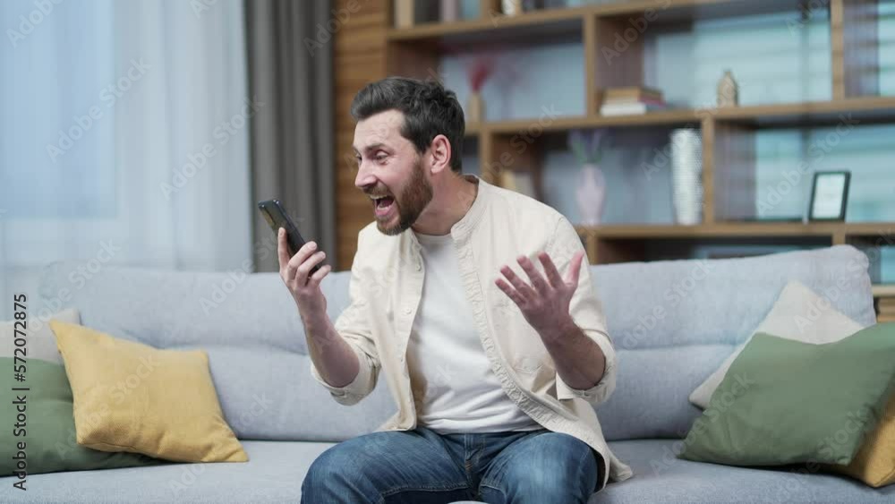 Irritated arguing bearded man yelling shouting into the smartphone gadget microphone at home Angry nervous mature male talking expressing negative emotion during phone call Bad conflict conversation Irritated arguing bearded man yelling shouting into the smartphone gadget microphone at home Angry nervous mature male talking expressing negative emotion during phone call Bad conflict conversation