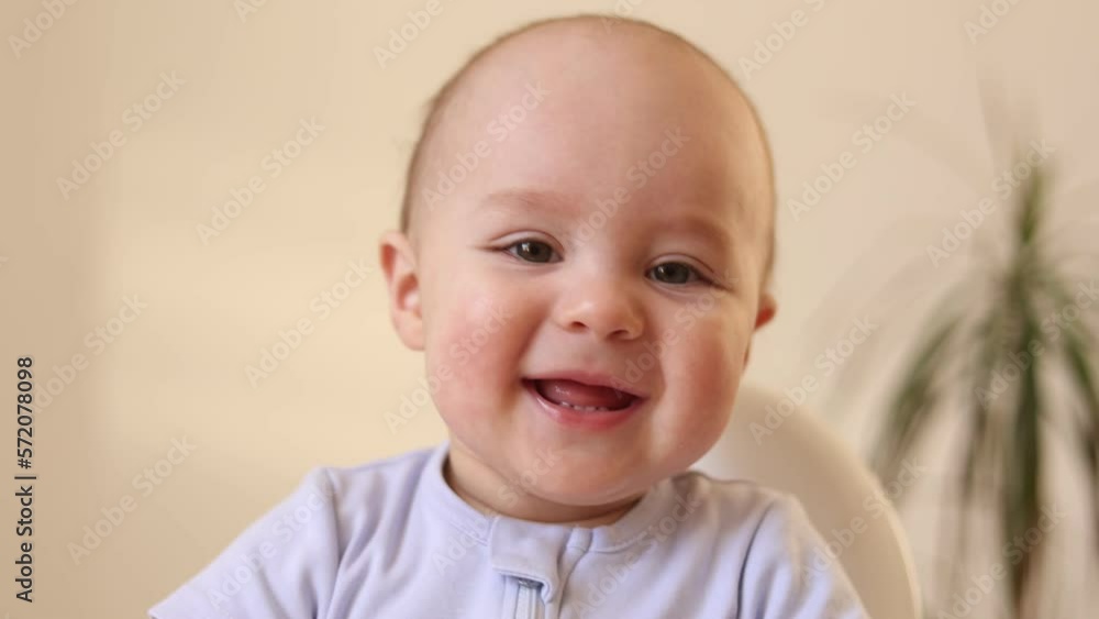 a cute kid in a yellow bodysuit is sitting in the kitchen with cans of baby food. The first complementary feeding of the child. Baby purees. High quality photo