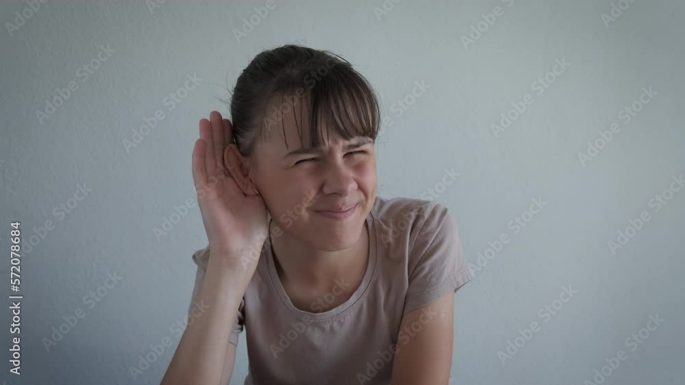 Put hand for better hearing. A teen with health problems try to hear better putting her hand by the ear in the room. Put hand for better hearing. A teen with health problems try to hear better putting her hand by the ear in the room.