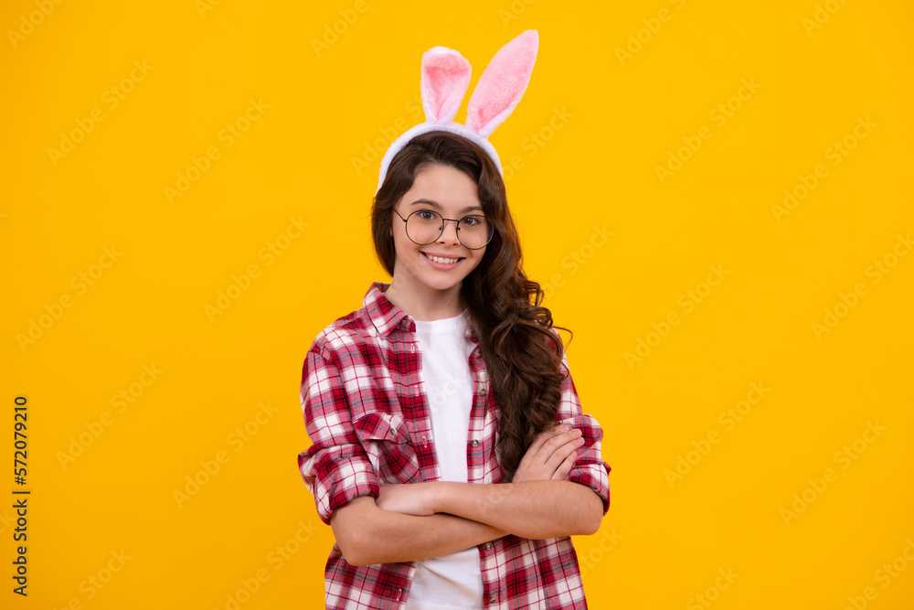 Portrait of teenager child wearing bunny ears isolated at yellow background. Happy teenager, positive and smiling emotions of teen girl.