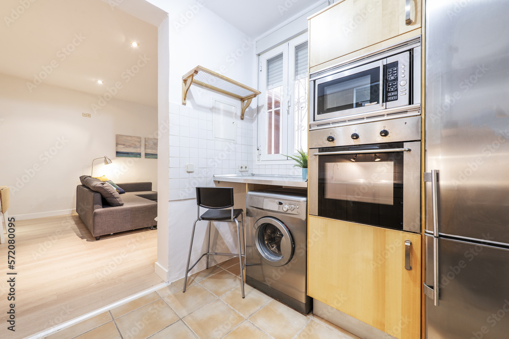 Detail of a kitchen without doors with wooden furniture and stainless steel appliances Detail of a kitchen without doors with wooden furniture and stainless steel appliances