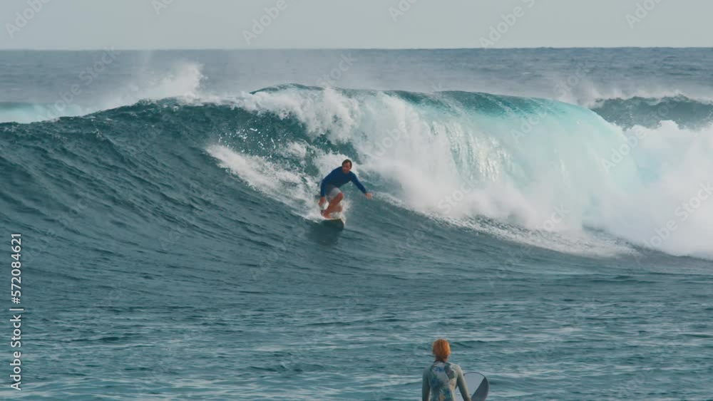 Surfer surfs the wave. Male surfer rides the wave in the Maldives Surfer surfs the wave. Male surfer rides the wave in the Maldives