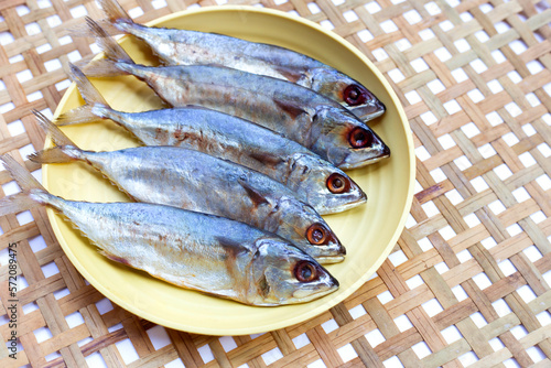 Salted fish in yellow plat on bamboo weave plate