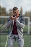 Athletic man in sportswear pumps his biceps with an elastic band