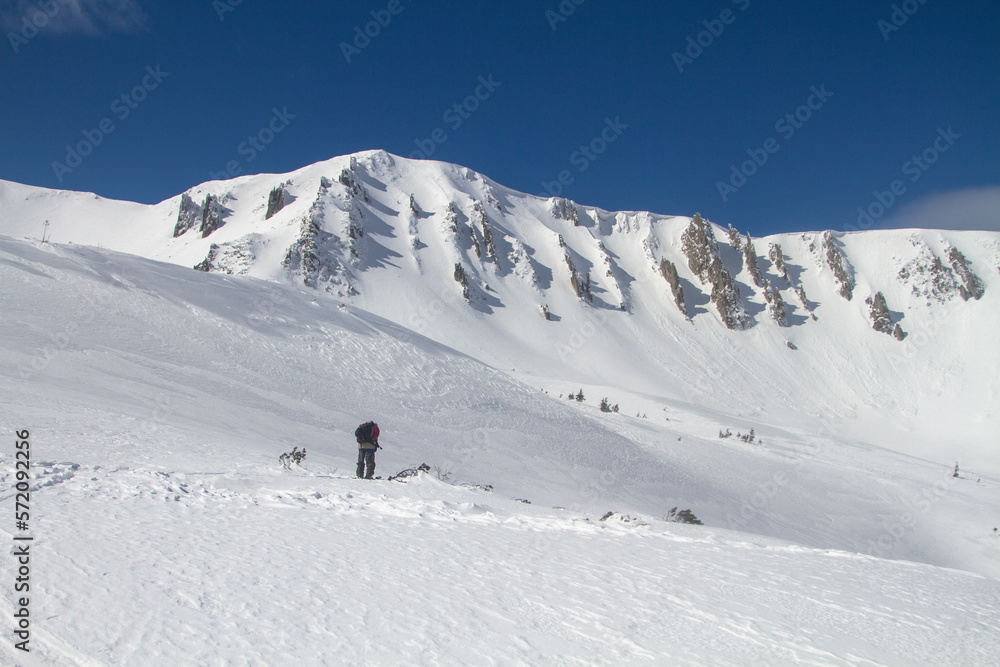 Ski touring in mountains, winter freeride extreme sport. Skiing in the snowy mountains
