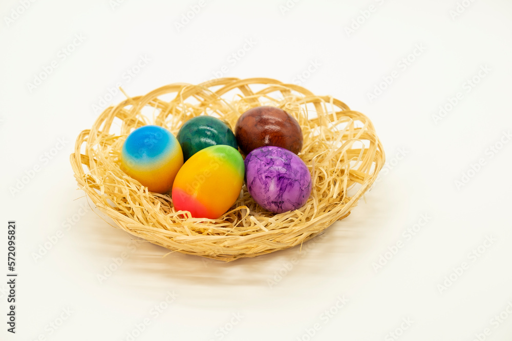 Easter painted eggs in a basket with straw on a light background.Easter food.Spring religious holiday. Easter painted eggs in a basket with straw on a light background.Easter food.Spring religious holiday.