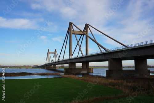 Bridge with motorway the Willem Alexander bridge over the river Maas built on pillars and connecting land. Dutch bridge where industry ships pass under. © Sailographic Paula