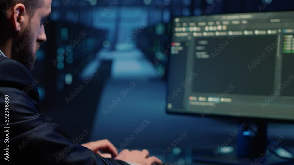 Database admin checking mainframe system on computer in data center, working with security protection for hosting server. IT administrator activating hardware system in cyberspace. Handheld shot. Database admin checking mainframe system on computer in data center, working with security protection for hosting server. IT administrator activating hardware system in cyberspace. Handheld shot.