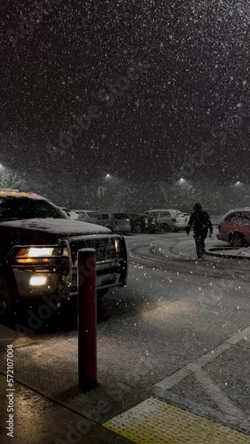 beautiful heavy snowfall in the evening near the store silhouette of a man and a car