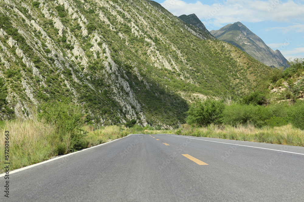 Fototapeta premium Beautiful view of empty asphalt highway near mountains outdoors. Road trip