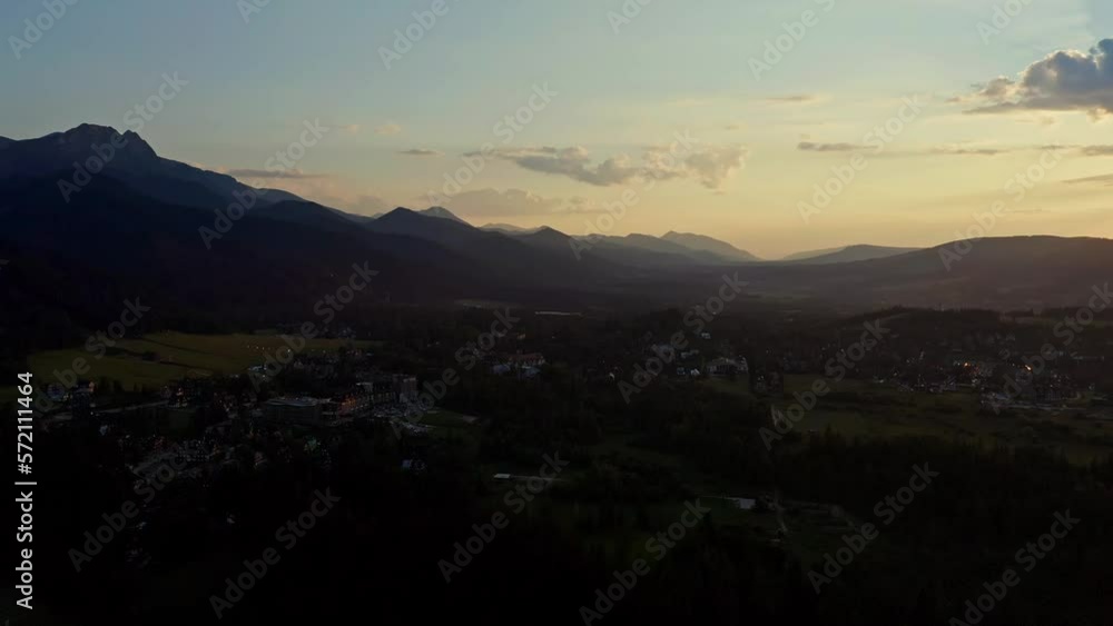 Resort Town Of Zakopane During Sunset With Mountain Range At The Background In Southern Poland. Aerial Wide Shot Resort Town Of Zakopane During Sunset With Mountain Range At The Background In Southern Poland. Aerial Wide Shot